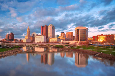 Downtown cityscape of Columbus, Ohio, with the reflection of the city in the Scioto River at spring sunset.