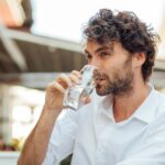 Man drinking water because he gave up alcohol for Lent