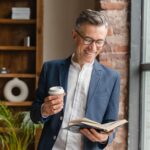 well-dressed successful man engaging in daily habit of reading a book