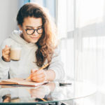 woman writing resolutions in journal