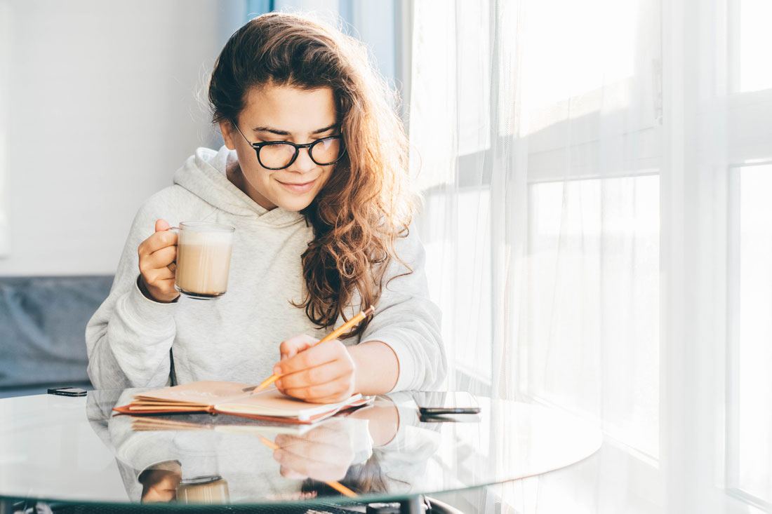 woman writing resolutions in journal