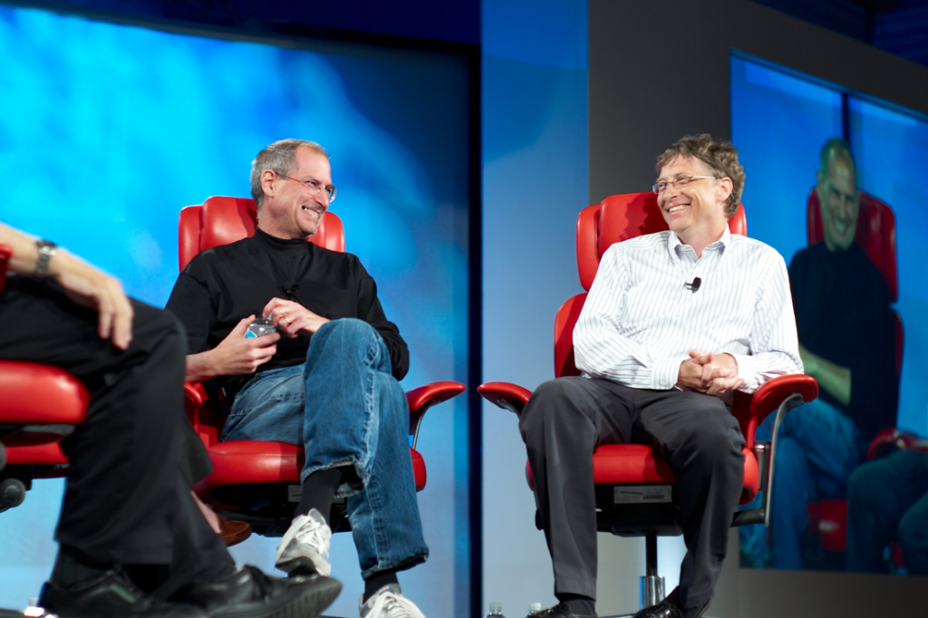 Steve Jobs and Bill Gates sitting in red chairs.