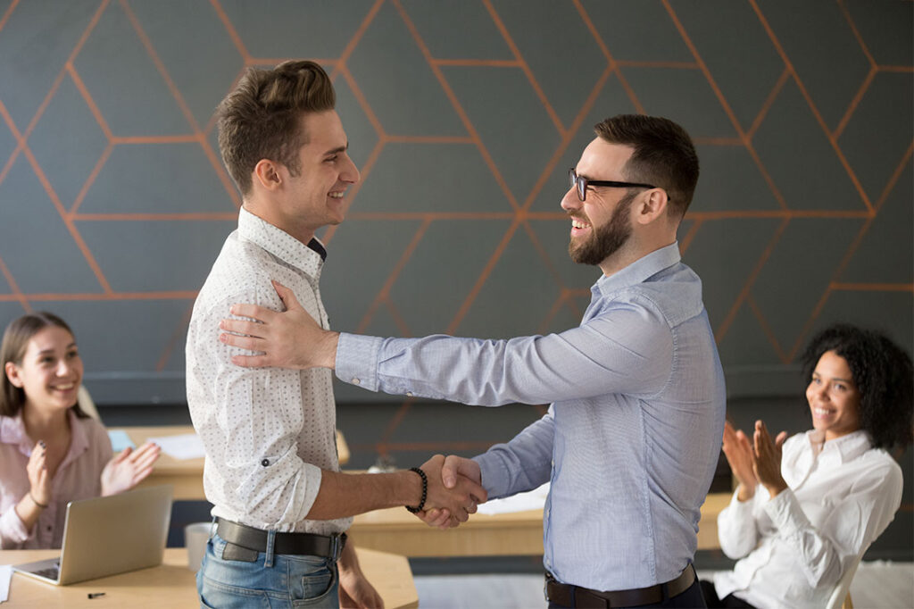 Team leader handshaking employee congratulating with professional achievement