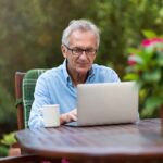 man sitting outside writing to be a better leader