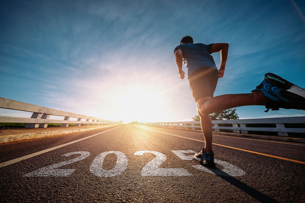 Man running on track with 2025 written on ground