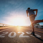 Man running on track with 2025 written on ground