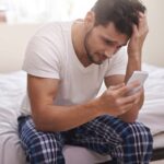 upset man looking at phone