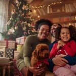 Happy family in front of their Christmas tree reading quotes about Christmas