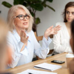 Muture business women showing younger staff how to start a mentoring program