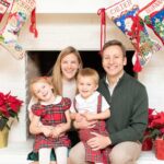 Bauble Stockings founder Kate Stice Stewart and her family on Christmas in front of a fireplace with Bauble Stockings hanging