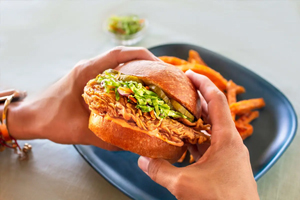 UPSIDE Foods chicken sandwich in hands, the most innovative company of 2024