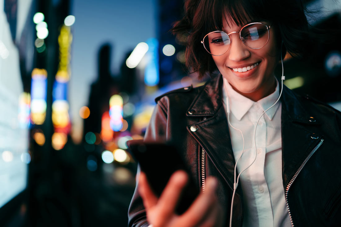 Women reading the best books about technology on her phone and listening to the top tech podcasts