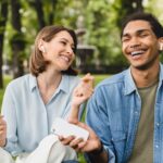 Couple listening to relationship podcasts together outside smiling