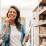 businesswoman smiling in her store of pottery because she's learning the difference between hard skills vs soft skills