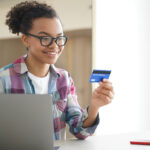 African American teenager looking at her debit card