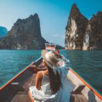 Young women on a boat in a the tropics using Solo travel tips