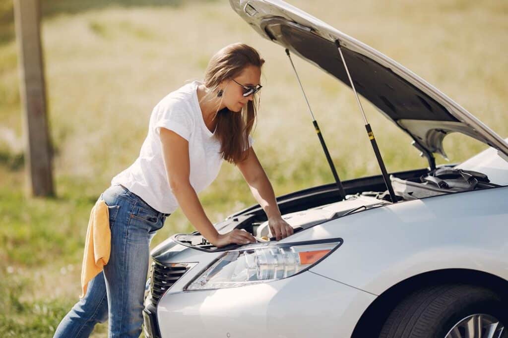 Young women doing road trip car maintenance