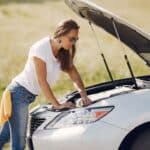 Young women doing road trip car maintenance