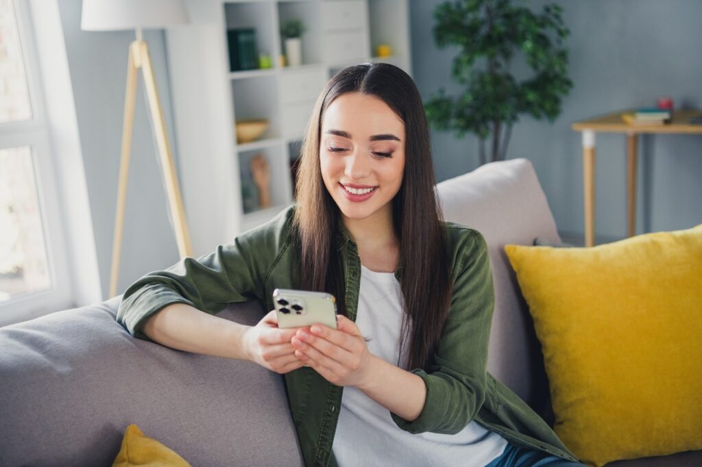 woman sitting on a couch using her phone