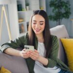 woman sitting on a couch using her phone