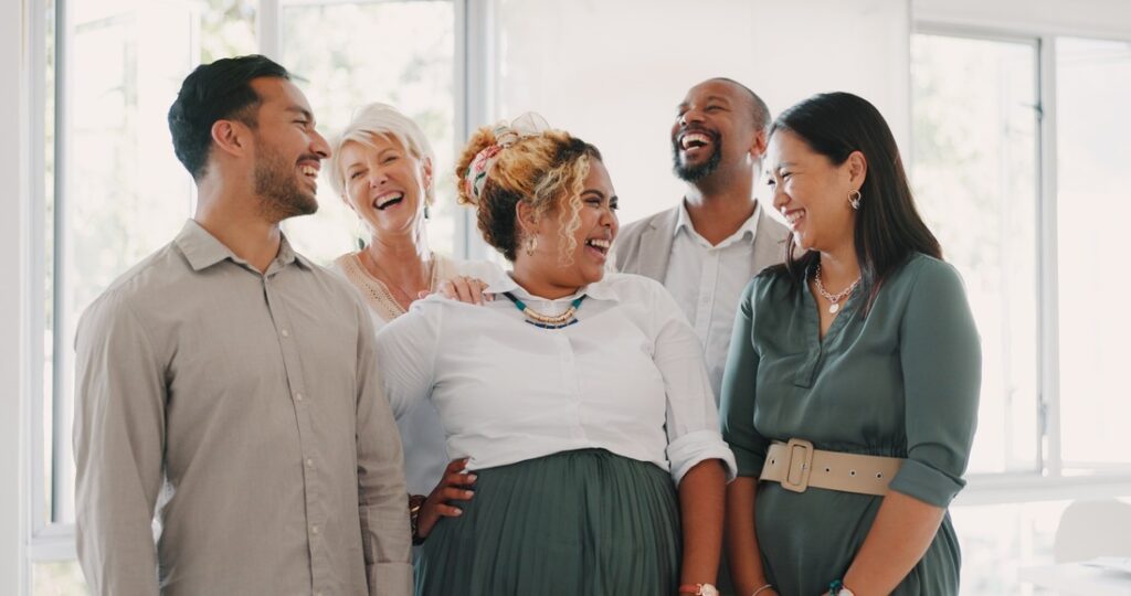 a group of people standing together and smiling at one another