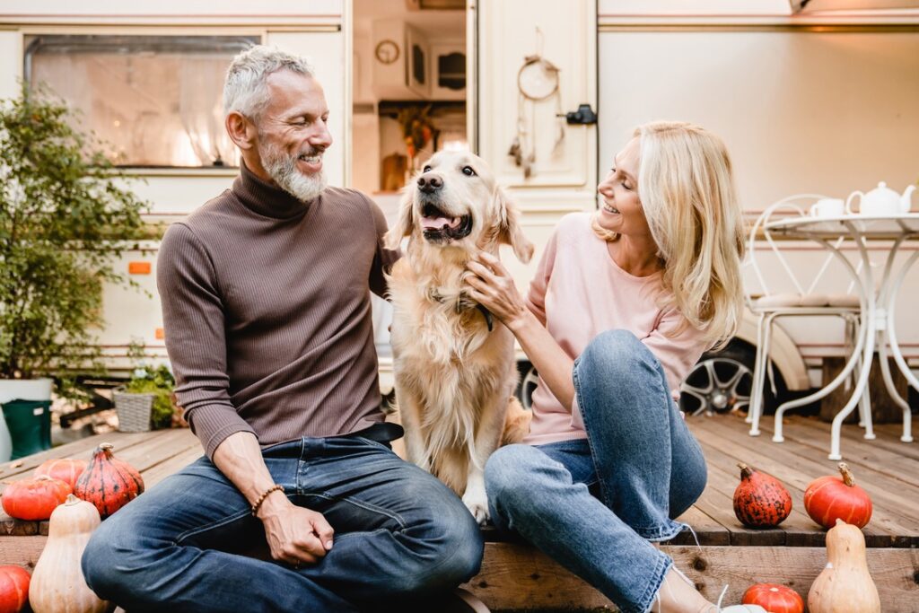 man and woman sitting with their dog