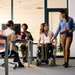 woman talking to female coworker in wheelchair