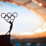 An Olympic statue depicting a man holding up the Olympics symbol.