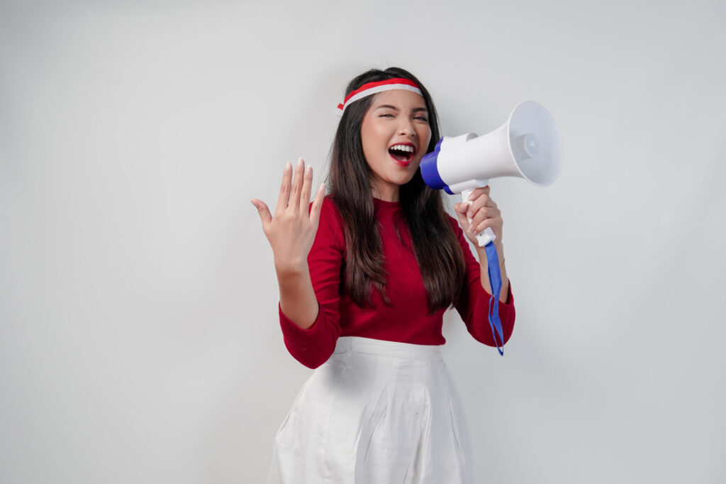 Young women shouts through a megaphone and shows how to promote your business