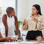 Diverse group ofyoung business women brainstorming at workplace