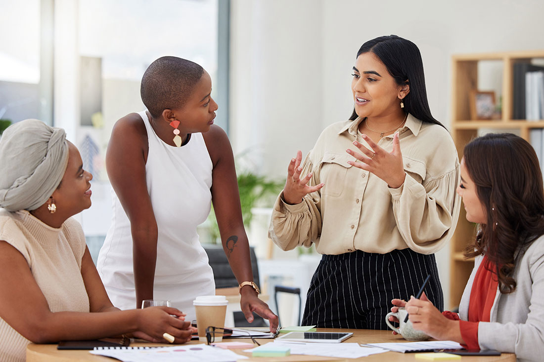 Diverse group ofyoung business women brainstorming at workplace