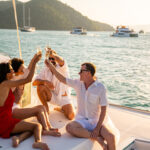 group of men and women toasting with drinks on a boat