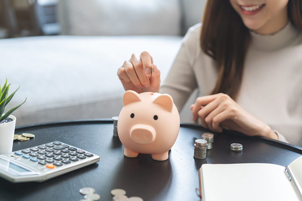 Woman putting money in a piggybank