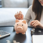 Woman putting money in a piggybank