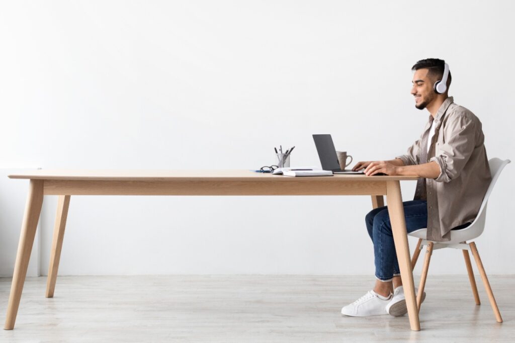 A freelancer works at the end of a long table.