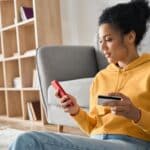 Women at home on her phone using empower budget app