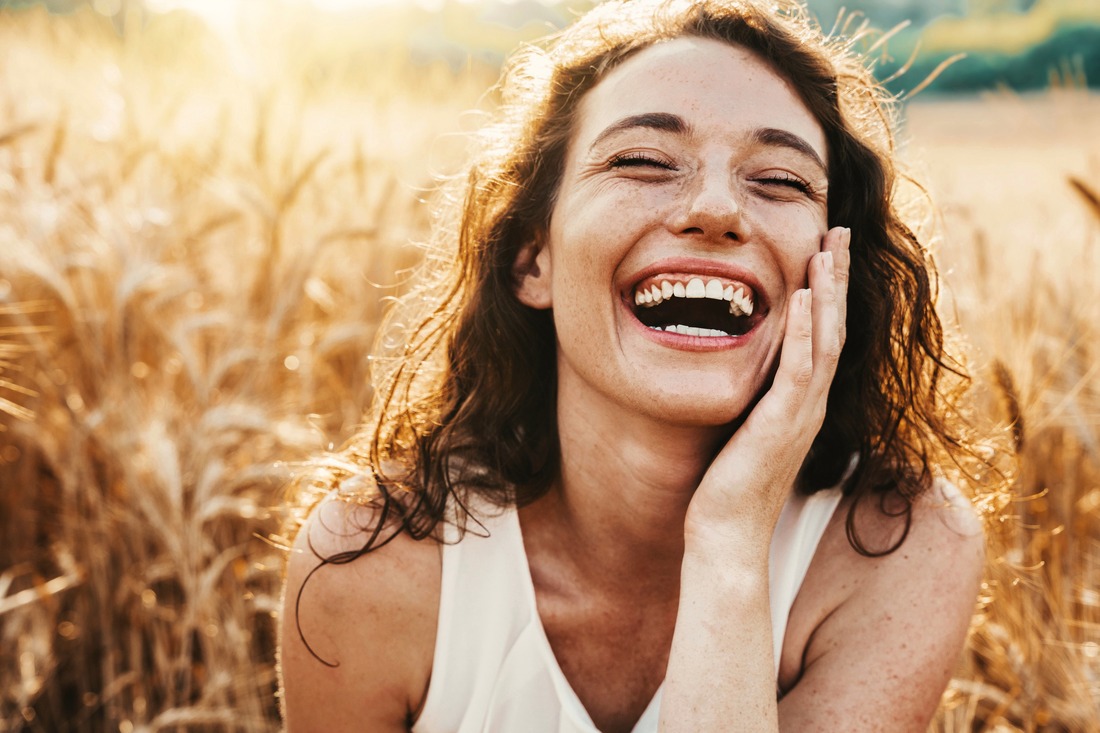 a woman smiling in a field