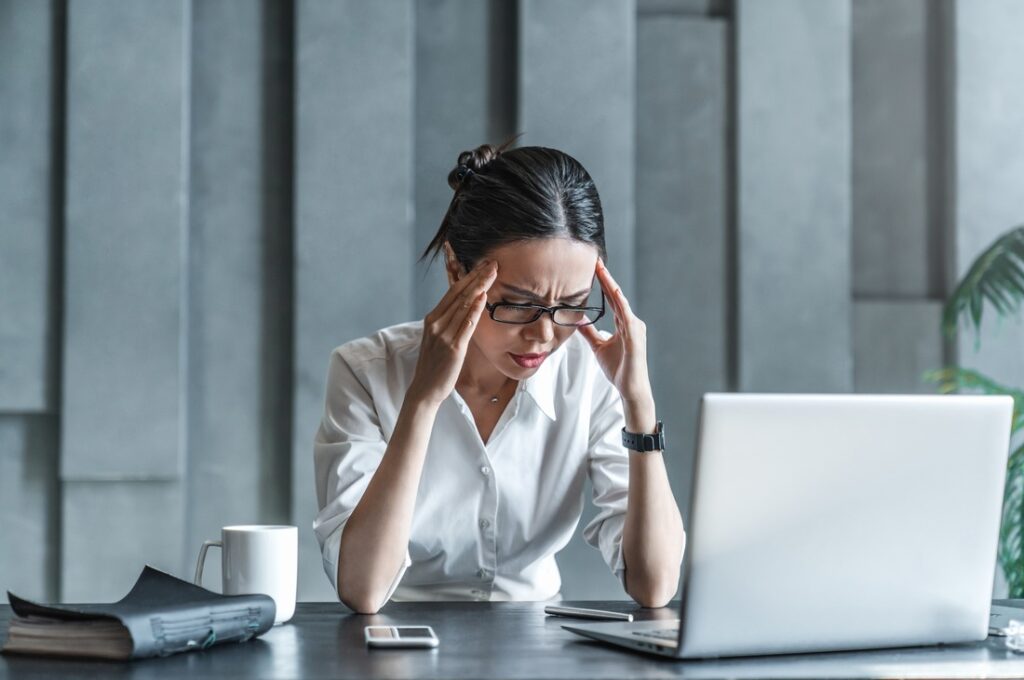 a woman sitting at her desk looking stressed