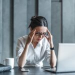 a woman sitting at her desk looking stressed