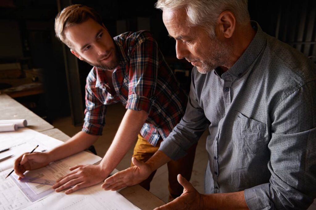 Father and son discussing leadership transitions in family-owned businesses