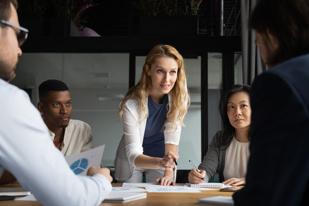 Confident businesswoman explains report to colleagues