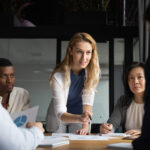 Confident businesswoman explains report to colleagues