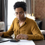 woman calculating finance and taxes with laptop computer at home workplace