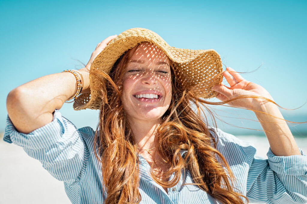 a woman smiling while at the beach