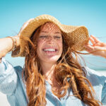 a woman smiling while at the beach