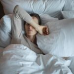 woman laying in bed struggling to sleep