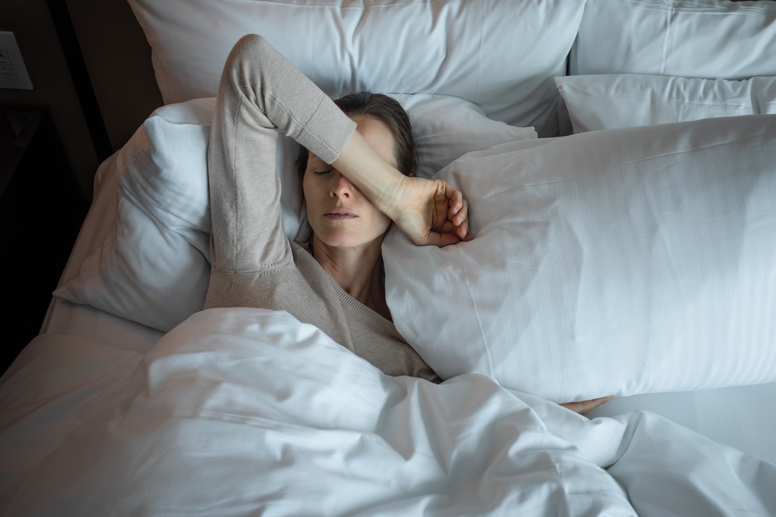 woman laying in bed struggling to sleep