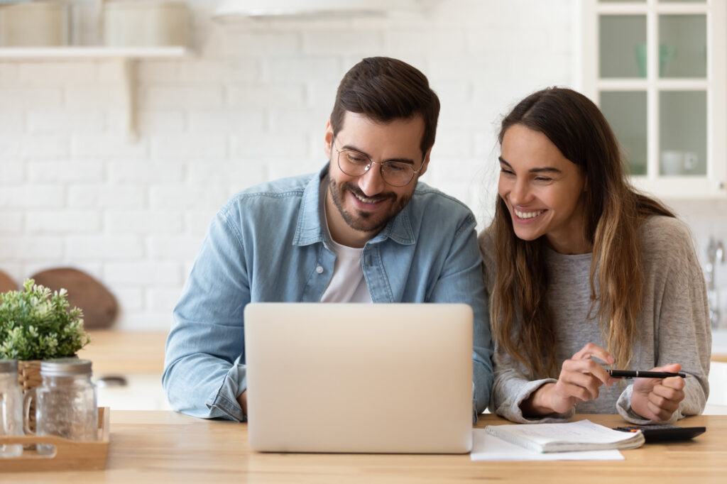 a couple looking at a laptop while financial planning