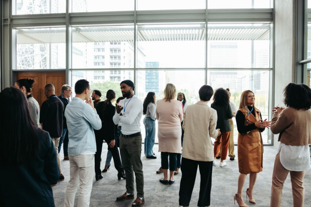 A large group of professionals, many of whom are holding conversations with each other.