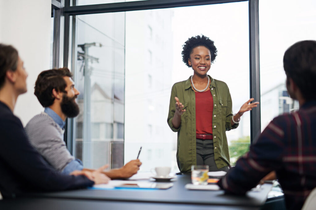 Young business women uses communication skills to talk to a table of people